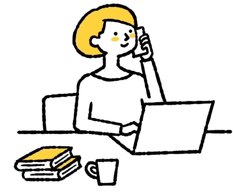 パソコンを見ながら電話をかける女性